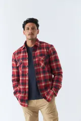 Sobrecamisa de algodón a cuadros color ladrillo, con interior de corderito, cierre con botones, bolsillos tipo cartera y logo en goma. El modelo usa talle M.