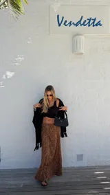 Ruana negra de tejido liviano con terminación de flecos en el ruedo y mangas amplias.