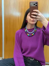 Collar corto de cuentas, compuesto por cuentas cuadradas celestes intercaladas con cuentas esféricas amarillas pequeñas.