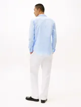 Camisa celeste de corte slim, confeccionada en tejido dobby de algodón con Flex Technology, cuello con botones, puños redondeados con dos botones y logo de Tommy Hilfiger bordado en el pecho.