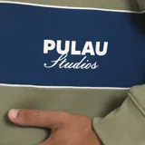 Buzo estilo rugby de manga larga, con cuello camisero en contraste de color azul oscuro. Presenta una franja horizontal ancha en color crema en el pecho con el logo de la marca bordado, y cuerpo en color azul claro.