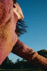 Sweater tejido de punto en hilado bouclé con degradé de colores naranja y rosa. De calce al cuerpo, cuello alto y suave textura.