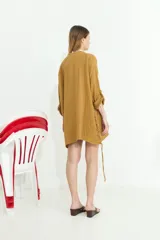 Camisa de algodón blanca, de manga larga y corte oversize, con diseño abierto en los laterales ajustable mediante cordón y ojalillos.
