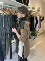 Pantalón marrón acampanado de gabardina elastizada con ojalillos metálicos en los laterales.