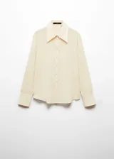 Camisa color crema de corte recto, cuello camisero y mangas largas con puños abotonados.