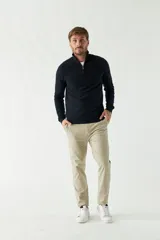 Sweater de punto azul marino con cuello alto y medio cierre con cremallera. Tiene puños acanalados y logo bordado en el pecho.