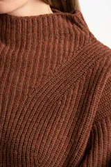 Polera de lana color marrón, con cuello alto, diseño acanalado y corte oversize con mangas anchas.