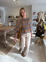 Blusa de manga larga con diseño de cuadros en tonos camel y azul, confeccionada con tejido elástico fruncido en todo el cuerpo y las mangas.