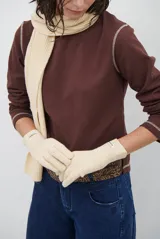 Remera de manga larga con cuello redondo, confeccionada en tejido de punto gris melange con costuras visibles en contraste.