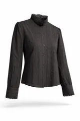Camisa de manga larga color negro, con cuello alto y cierre frontal de botones. Presenta detalles de encaje y bordados verticales a lo largo de toda la prenda, incluyendo los puños.