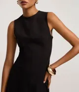 Vestido midi evasé de la marca Cortelle, confeccionado en bengalina de algodón con elastano. Presenta cuello redondo, diseño sin mangas con breteles anchos y cierre trasero mediante cremallera.