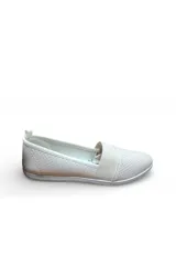 Zapatilla slip-on Moleca de color beige, con diseño perforado en la capellada, banda elástica cruzada en el empeine y suela plana de goma blanca.