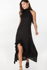 Vestido midi marrón de lino italiano, con cuello halter, sin mangas y diseño asimétrico con volados en el ruedo.