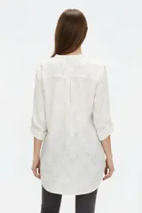 Blusa de viscosa color bordó, con cuello en V, cierre frontal parcial con botones, mangas tres cuartos y bolsillo aplicado en el pecho.