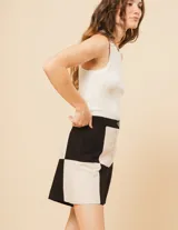 Short de lino color beige y naranja, de tiro alto con elástico en la pretina trasera, cierre delantero y botón, bolsillos delanteros y dobladillo invisible.