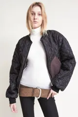 Campera bomber color marrón oscuro con cuello alto, puños y ruedo acanalados. Estampado en la espalda con la palabra "Bestia" en letras góticas.