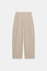 Pantalón barrel color azul marino, de tiro bajo, pernera holgada con diseño redondeado que se estrecha hacia el tobillo, con bolsillos delanteros y cierre frontal.