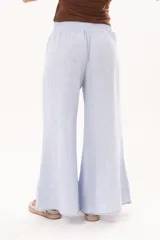 Pantalón palazzo celeste de tiro alto, con cintura elástica fruncida y diseño amplio de pernera ancha.