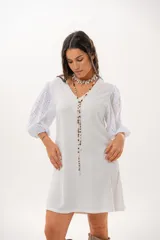 Vestido corto off-white con escote en V, de corte recto y holgado. Cuenta con mangas abullonadas tres cuartos confeccionadas en tejido broderie.