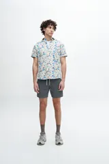 Camisa de manga corta confeccionada en tela 100% algodón con estampado de cachemir en tonos naranja y celeste. Tiene un bolsillo en el pecho y botones personalizados.