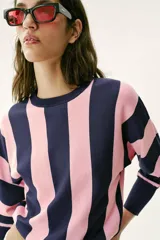 Sweater de punto con diseño de rayas verticales anchas en color azul marino y rosado, cuello redondo y mangas largas con puños ajustados.