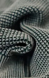 Sweater de cuello redondo con diseño de tejido texturizado en color verde y blanco. Presenta un calce relajado y terminaciones en punto rib en el cuello.