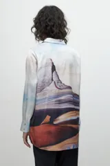 Camisa celeste de manga larga con estampa de paisaje.