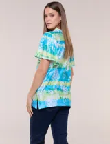Blusa de rayón en tonos turquesa y verde, con cuello en V con detalles bordados, mangas cortas amplias y diseño estampado con motivos florales y geométricos.