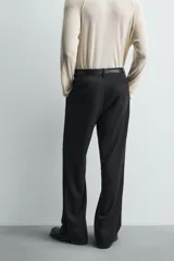 Pantalón de corte relaxed fit confeccionado en tejido con mezcla de lana, con bolsillos delanteros y traseros de vivo, cierre frontal con cremallera y botón.