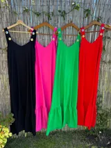 Vestido largo fucsia con breteles finos y detalle de tachas doradas en los breteles.