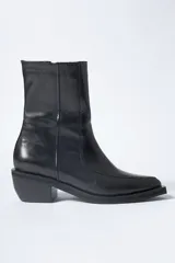 Bota de caña media confeccionada en cuero negro con acabado brillante, diseño de silueta limpia, puntera cuadrada y taco cuadrado de altura media.