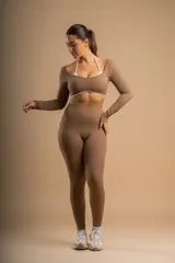 Top deportivo marrón de manga larga con escote cuadrado y banda elástica blanca en el bajo busto.