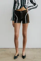 Short de denim marrón con apliques blancos en el frente.