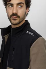 Campera tipo fleece con cierre frontal completo, cuello alto y bolsillo en el pecho. Presenta un diseño de paneles en contraste de color azul marino y gris oscuro, con logo de la marca Benson & Thomas estampado en el hombro.
