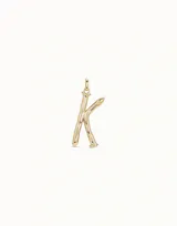 Charm unisex con forma de letra "K" estilizada, inspirado en la forma de un clavo, con acabado dorado. Posee una argolla superior para colgarlo.