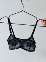 Top negro de microtul con estampado de lunas y estrellas, breteles finos regulables y ribete de puntilla.