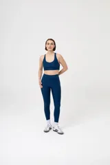 Calza larga deportiva color verde oscuro, de tiro alto, con bolsillos laterales y costuras reforzadas.