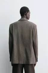 Blazer de corte regular fit confeccionada en tejido de mezcla de lino y lana. Presenta cuello con solapas de muesca, cierre frontal de un botón, bolsillos de solapa en la cadera y bolsillo de vivo en el pecho. Cuenta con mangas largas con puños abotonados, bolsillo interior y abertura central en la espalda.