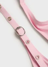 Top de bikini triangular color rosa con detalle de eyelets metálicos en los breteles. Se ata en la espalda con lazos y tiene relleno.