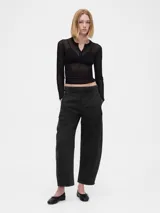 Pantalón de corte barrel, tiro medio, confeccionado en denim de color negro lavado. Presenta un diseño de pierna ancha y curva, con cierre de botón y cremallera, y bolsillos laterales y traseros.