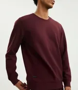 Buzo deportivo color verde claro, de manga larga y cuello redondo. Confeccionado en tejido de poliéster, viscosa y elastano.