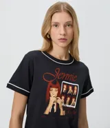 Remera negra de algodón con cuello redondo, manga corta y ribetes blancos contrastantes en cuello y mangas. Presenta una estampa fotográfica frontal de Jennie con tipografía en tonos rojos.