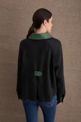 Campera corta en tono beige con cuello, puños, solapas de bolsillos frontales y detalles en cuero sintético marrón. Cuenta con cierre frontal de botones dorados y bolsillos aplicados.