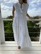 Vestido largo celeste de corte holgado, con cuello mao, mangas cortas y botones frontales.