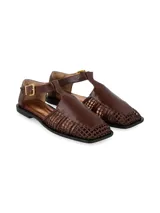 Sandalias planas de cuero color marrón chocolate, con diseño cerrado en la parte delantera que combina una puntera lisa y laterales de tejido entrelazado. Cuenta con tira ajustable al tobillo mediante hebilla metálica dorada.