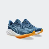 Championes de running Asics modelo Dynablast 5, con capellada de malla jacquard transpirable en color negro y blanco. Presenta entresuela con tecnología FF Blast+ para mayor amortiguación y retorno de energía, con suela de goma en color verde.