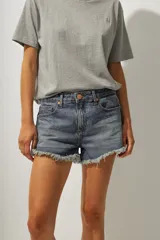 Short de jean de tiro medio con ruedo desflecado y cierre frontal con botón y cremallera.