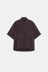 Camisa de cuello solapa y manga corta con dobladillo, presenta bolsillos de plastrón en el frente, bajo asimétrico y cierre frontal con botones ocultos.