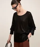 Blusa de punto color dorado, de acrílico y viscosa, con escote redondo, manga larga y sisa raglán. Tiene una malla con lámina metálica.