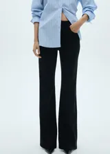 Pantalón de pana negro con diseño acampanado, tiro medio, cierre de cremallera y botón, y cinco bolsillos.